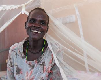 Nyanut is seen smiling in the hospital bed at the Reconciliation Hospital run by ELCAMSS