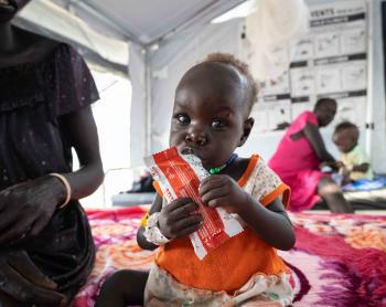 12-month-old Nyalam enjoys a sachet of ready-to-use therapeutic food (RUTF) at the Medair stabilization center in Akobo, marking a powerful milestone in her journey to full recovery from severe acute malnutrition