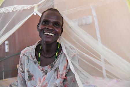 Nyanut is seen smiling in the hospital bed at the Reconciliation Hospital run by ELCAMSS